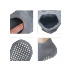 Four images of a gray sock. Top left: a finger stretching the socks opening. Top right: close-up of the socks opening. Bottom left: view of non-slip dots on the sole. Bottom right: sock worn on a foot, showing heel coverage and dot grip.