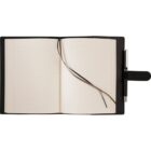An open black notebook with lined pages and two ribbon bookmarks lays flat. A pen is secured in a holder on the right side of the notebooks cover.