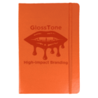 An orange notebook with a textured cover featuring an image of lips dripping with gloss and the words GlossTone High-Impact Branding. An elastic band is attached to the edge for closure.
