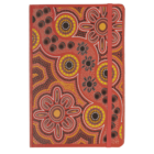 A red notebook with an Aboriginal-inspired dot painting design. The cover features circular patterns and floral shapes in yellow, orange, brown, and black hues. An elastic band is attached to keep the notebook closed.