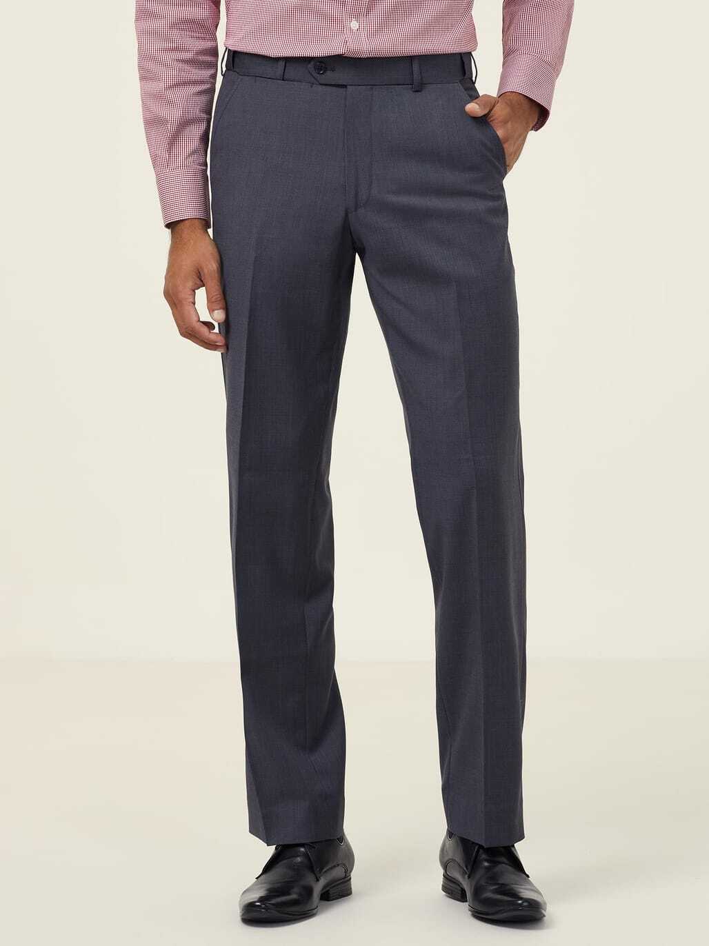 A person wearing a pink dress shirt and gray dress pants is standing against a neutral background. The shirt is long-sleeved, and the pants are straight-cut. Only the upper legs and torso are visible. The person is also wearing black shoes.