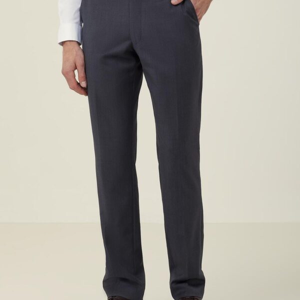 A person is wearing dark gray dress pants, a white long-sleeved shirt, and brown dress shoes. Their left hand is in their pocket, and they have a black belt. The background is plain off-white.