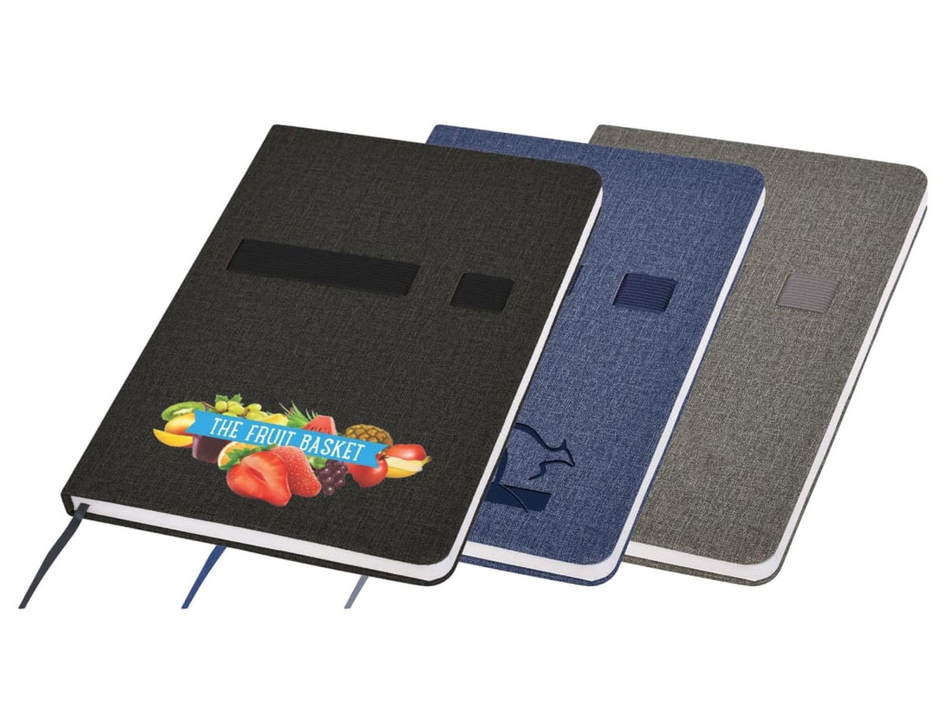 The Emz A5 Notebook collection features three hardcover options with fabric covers in black, blue, and gray. The black version has a fruit logo and The Fruit Basket text. All notebooks include a ribbon bookmark and an elastic band closure for convenience.