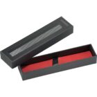Black rectangular gift box with a mesh window, containing a red item secured by a black ribbon.