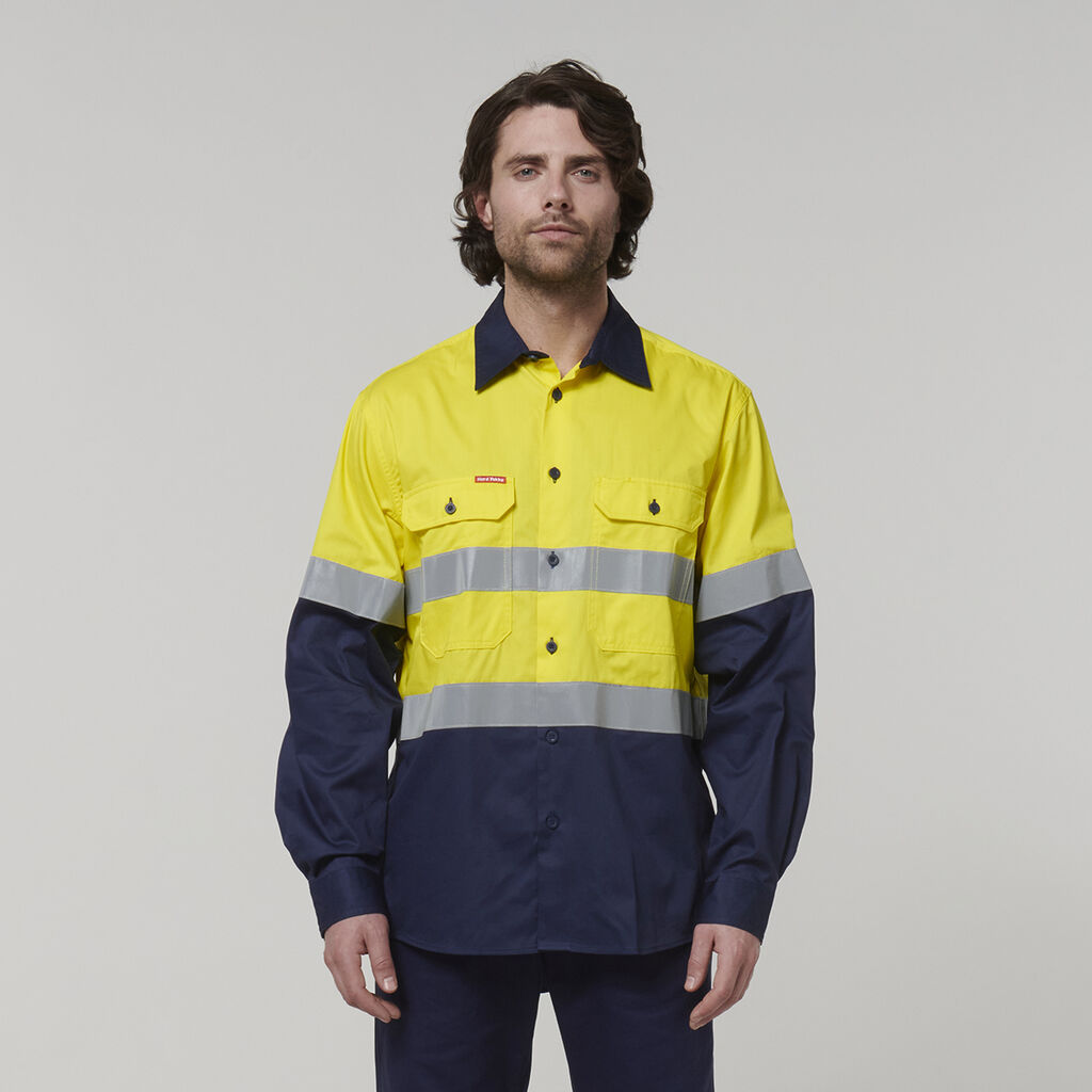 A person wears a high-visibility, long-sleeve work shirt with a bright yellow top and dark blue bottom. It features reflective gray stripes on the chest and arms, set against a plain light gray background—ideal for jotting notes in your Emz A5 Notebook or channeling your inner Emz.