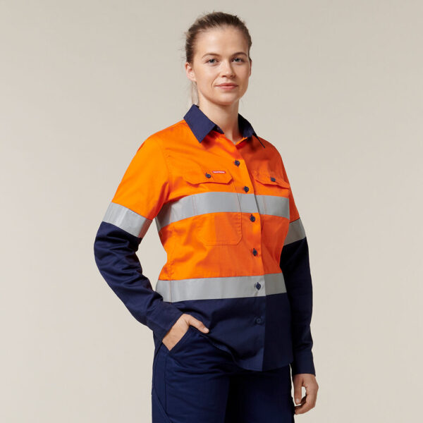 Woman wearing Explorer Shield hi-vis shirt with reflective stripes, smiling.