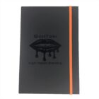 A black notebook with the words GlossTone High-Impact Branding and a graphic of glossy lips with dripping gloss. It has an orange elastic band on the right side.