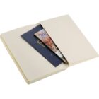 An open notebook with pockets, holding two passports and a colorful map or pamphlet. The notebook has blank, pale pages and a soft cover.