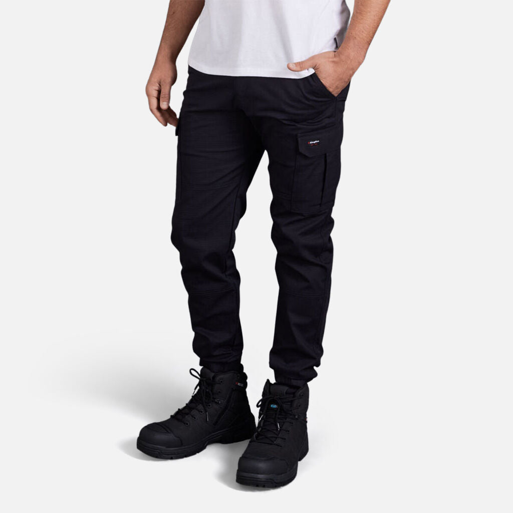 Model wears Explorer Shield tee with black cargo pants and boots against white background.