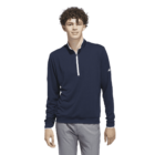 Young man in a navy quarter-zip pullover and gray pants, standing against a white background.