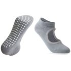 Two gray non-slip socks, one showing the white grip dots on the sole and the other displaying a cut-out design on the top, both on a white background.
