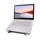 A silver laptop on a black stand, displaying a landscape on its screen.