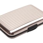 Silver metal card holder with ridged surface and a black clasp, shown closed.