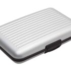 A silver, ribbed, hard-shell wallet case with a black latch, closed.