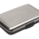 A silver, ribbed, rectangular metal card holder with a black clasp.