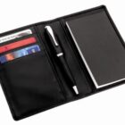 Black checkbook holder with a pen, blank checkbook, credit cards, and cash inside.
