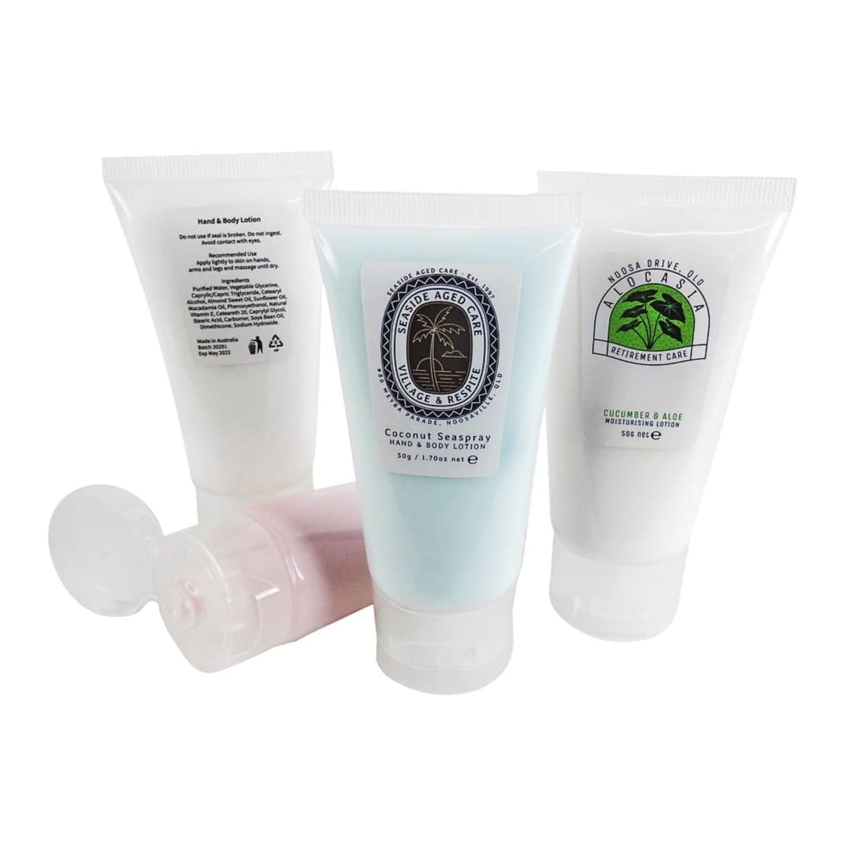 Four tubes of lotion with different labels and colors, two upright and two lying down.