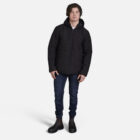Man in black jacket and Explorer Shield boots stands against a white background.