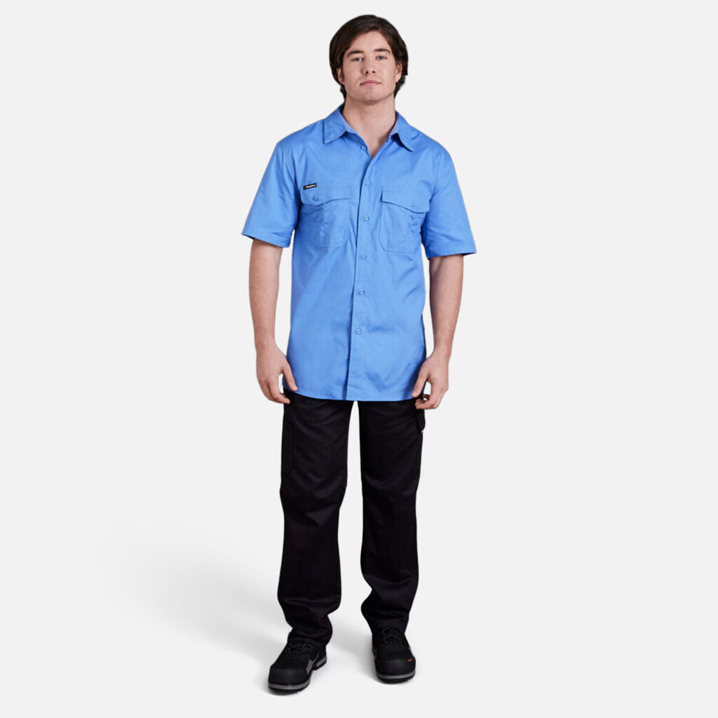 Man wearing the Explorer Shield blue short-sleeve shirt and black pants on a white background.