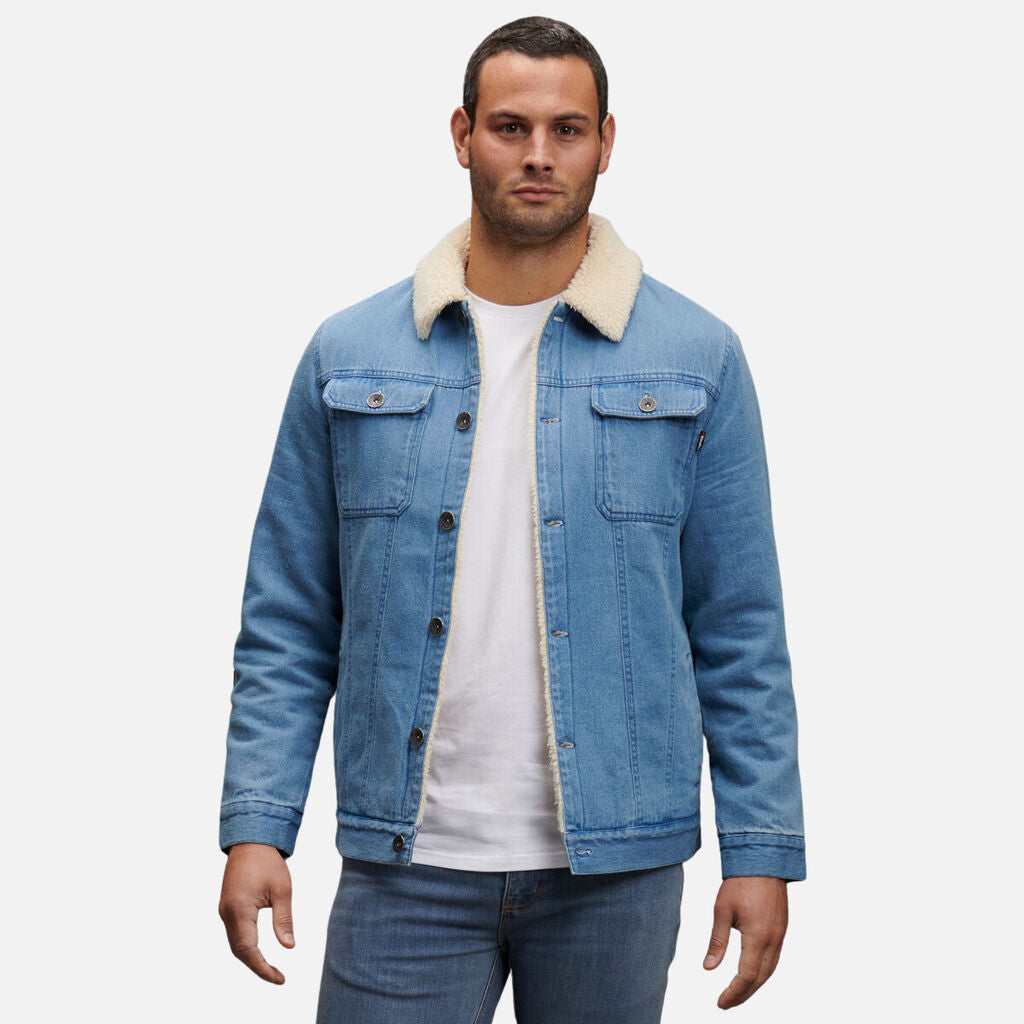 Man stands forward in jeans and light blue denim jacket with Explorer Shield accent.
