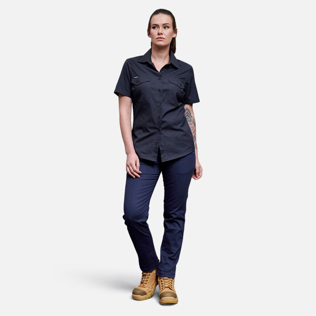 Person in a navy Explorer Shield short-sleeve shirt, navy pants, and tan work boots.