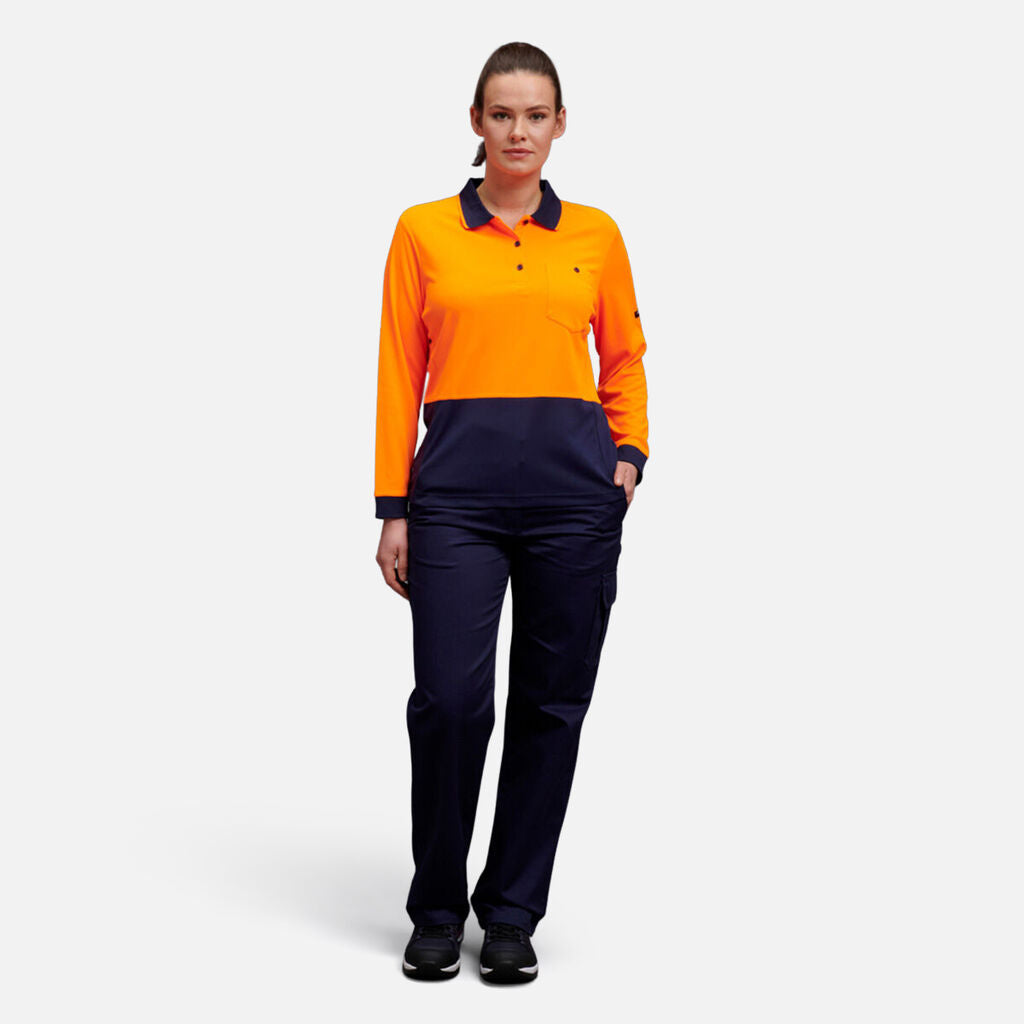 A woman stands facing forward in an orange and navy Explorer Shield long-sleeve uniform.