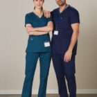 Two healthcare professionals in scrubs stand side by side, smiling at the camera.