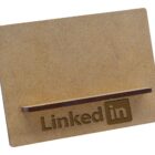 A plain wooden card holder with a LinkedIn logo engraved on the front.