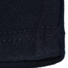 Close-up of a dark knitted fabric with visible stitching along the edge.
