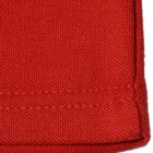 Close-up of a red fabric with visible stitching and textured weave.
