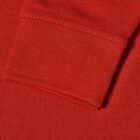 Close-up of a red fabric sleeve cuff on a textured garment.