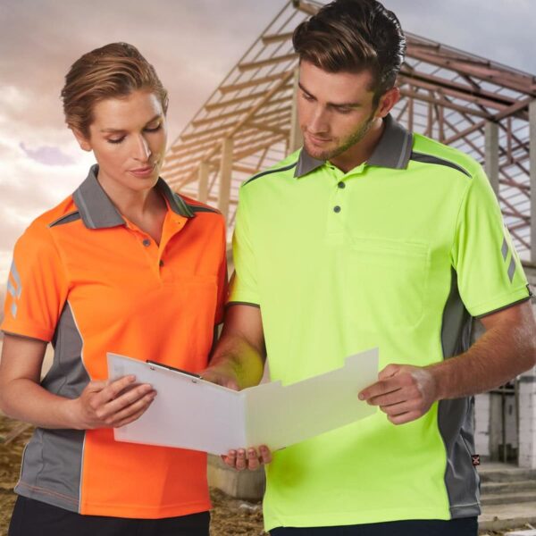 Two people in safety shirts review documents at a construction site with a steel frame.