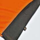 Close-up of an orange and dark gray fabric with stitching and a small black tag.