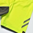 Close-up of a neon yellow garment with gray accents and diagonal stripes.