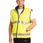 Man wearing a yellow reflective safety vest over a white shirt, with hands in pockets.