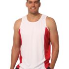 Smiling man in a white and red sleeveless athletic tank top, standing with one hand in pocket.