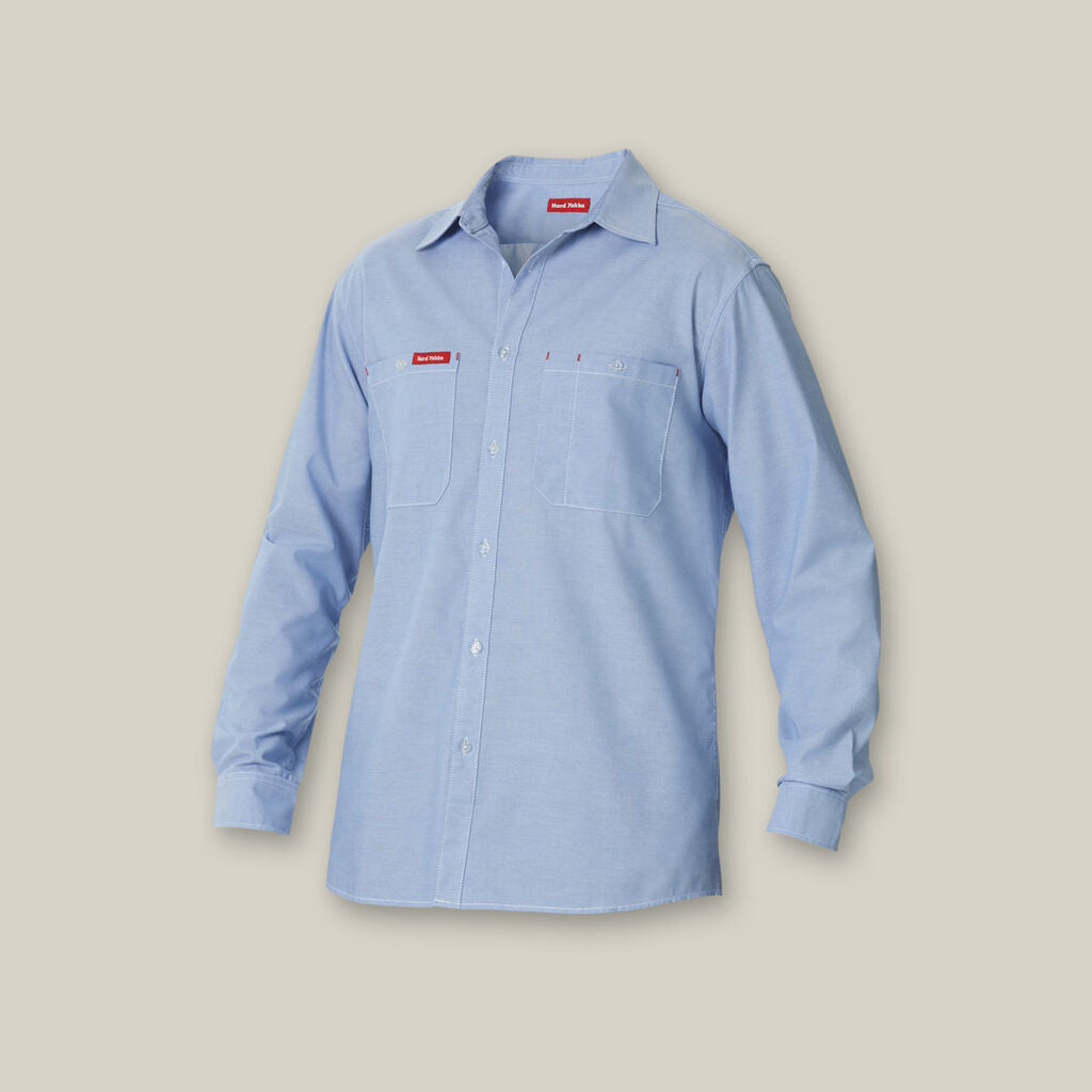 Light blue Explorer Shield long-sleeve shirt with chest pockets, beige background.