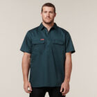 Man in a dark green Explorer Shield short-sleeve button-up shirt with two chest pockets.