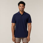 Man in a navy polo and tan shorts wears the Explorer Shield against a light background.