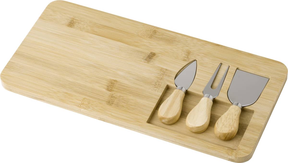 Wooden cheese board with three cheese knives in a groove.
