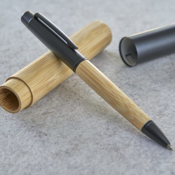 A bamboo pen with a matching case on a gray surface.