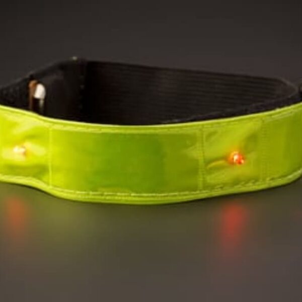 A neon green LED armband is displayed against a dark background. The armband, designed for visibility, features embedded red lights and a black interior lining.