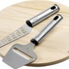 Cheese knife and slicer on a round wooden board.