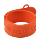Orange slap bracelet with NSW Velo text embossed on it.