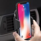 Phone mounted in a car vent holder with a colorful lock screen display.