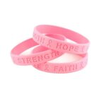 Three pink bracelets with Strength, Hope, and Faith embossed alongside ribbons.