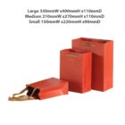 Three red paper bags of different sizes with handles.