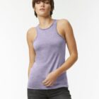 Person in a purple tank top and jeans standing against a plain background.