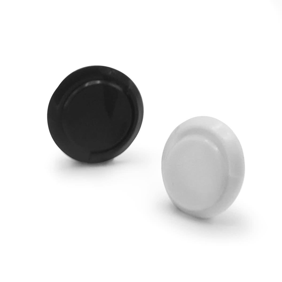 Black and white round plastic caps on a plain white background.