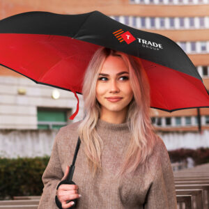 Blonde woman holds a black and red umbrella, part of a vibrant marketing campaign.